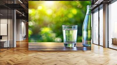 Closeup of glass bottle and glass full of fresh water, refreshing, hydration, purity,clear, liquid Wall mural