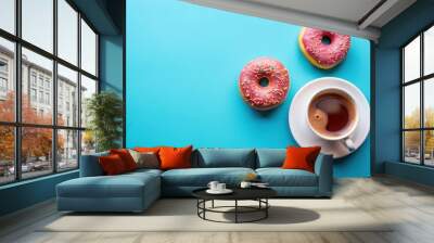 Overhead view of coffee cup, OMG sign, and sweet donuts isolated on blue background Wall mural