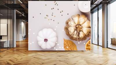 Decorative pumpkins, golden confetti and dry leaves on gray background. Autumn concept Wall mural