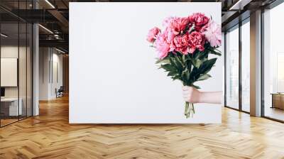 Female hand holds beautiful bouquet of peonies. Flower delivery concept Wall mural