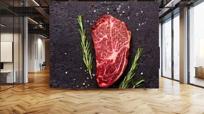 Fresh raw marbled beef rib eye steak and spices on black stone background Wall mural