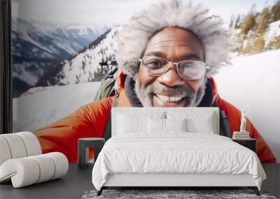 Happy mature african american hiker man taking selfie portrait on top of a snowy mountain Wall mural