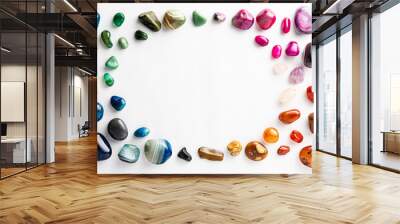 Colorful semi-precious stones arranged neatly with a circular empty space among them on a white background Wall mural