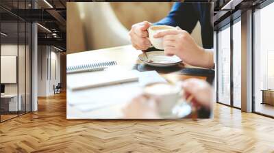 unrecognizable businessman having coffee at meeting with defocused business partner; documents, note Wall mural