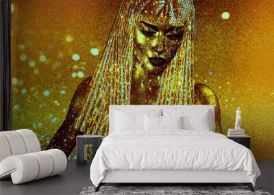 Beautiful black Egyptian queen or pharaoh with gold crown, fashion cosmetics, statue earrings posing against a stone textured wall with hieroglyphics.  Wall mural