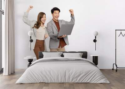 Asian businessman and businesswoman looking at laptop computer and hands up raised arms from happiness isolated on white background, Feeling happiness and winner success Wall mural