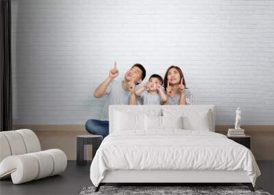 Asian family pointing with finger to top Wall mural