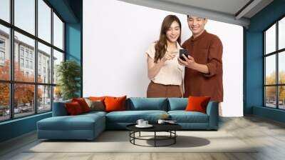 Happy Asian couple businessman and businesswoman using mobile phone isolated on white background Wall mural