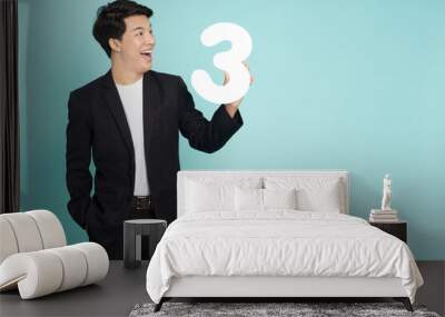 Young Asian business man showing number 3 or three isolated on green background Wall mural