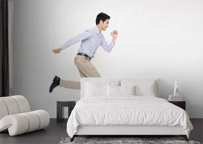 Young Asian businessman running forward isolated on white background Wall mural