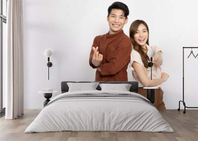 Young Asian couple showing mini heart sign isolated on white background, Spreading love and happiness concept Wall mural