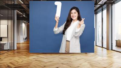 Young beautiful Asian woman showing number 1 and pointing up with finger number one isolated on blue background Wall mural