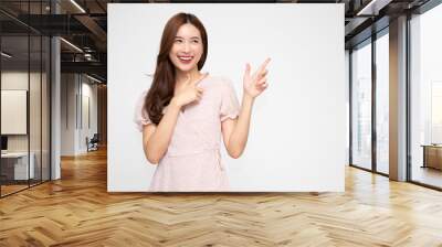 Young elegant beautiful Asian woman smiling and pointing to empty copy space isolated on white background Wall mural