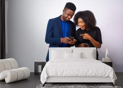 excited young man and woman viewing content on their phones feeling exited Wall mural