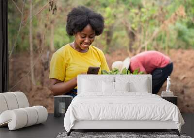 female african farmer making use of her phone Wall mural