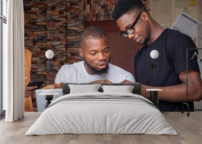 three african people, men, using mobile phones and laptop computer, sharing ideas Wall mural