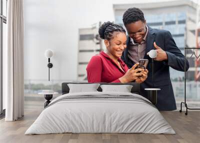 two young african business people checking a phone together Wall mural