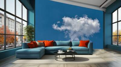 small white cloud floating gently as it is blown away by the winds under a blue sky. Wall mural