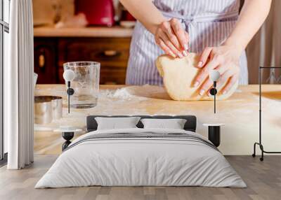 Woman's hands knead dough on a table Wall mural