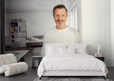 A businessman with white turtleneck sweater stands with a cup in the office Wall mural