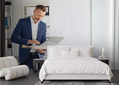 Attractive stylish businessman reading a binder Wall mural