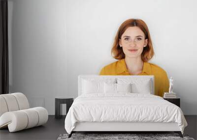 Attractive young redhead woman smiling at camera Wall mural