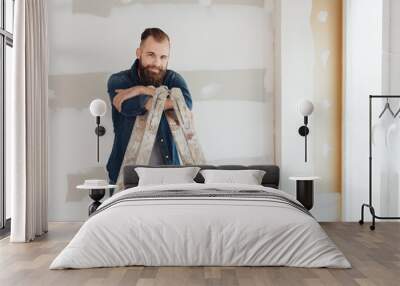 Bearded young man doing home improvements Wall mural