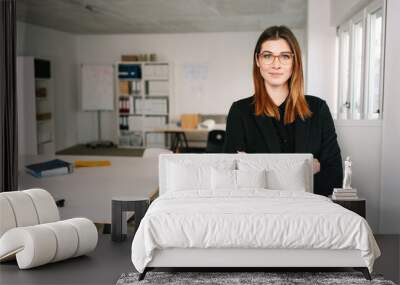 Confident happy young businesswoman in a large office Wall mural