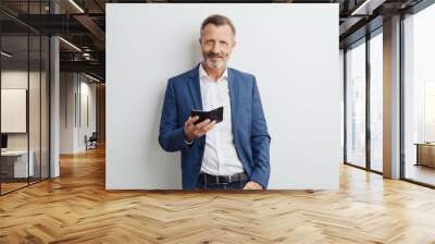 Confident stylish businessman holding a mobile Wall mural