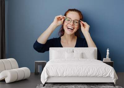 Cute laughing young woman wearing spectacles Wall mural