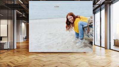 Fun loving young woman sitting in wooden dinghy Wall mural