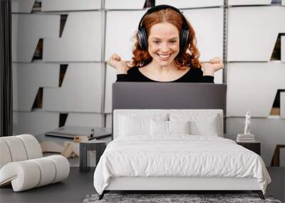 Happy business woman in headphones with laptop Wall mural