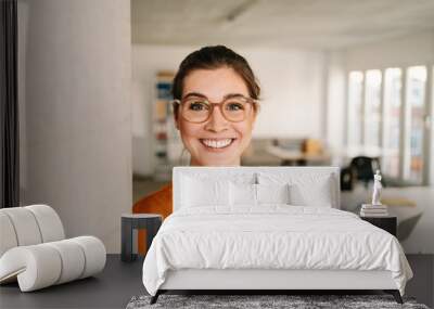 happy businesswoman with glasses in office looking at camera Wall mural