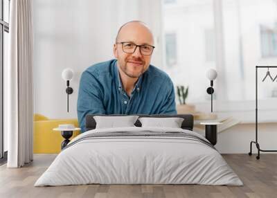 Happy friendly man wearing glasses with a book Wall mural