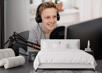 Happy friendly teenage boy recording a podcast Wall mural