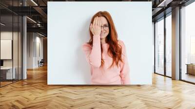 Happy smiling young woman covering her eye Wall mural