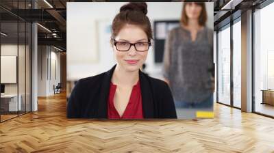 junge geschäftsfrau mit brille schaut in die kamera Wall mural