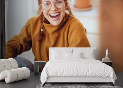 Pretty smiling girl with pigtails on chair Wall mural