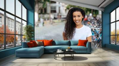 Smiling young woman in a quiet urban street Wall mural