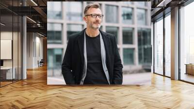 Street portrait of mature man wearing black coat Wall mural