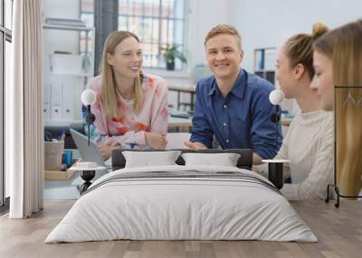 studenten sitzen zusammen am tisch und arbeiten an einem projekt Wall mural