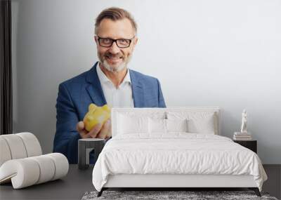 Successful businessman holding a piggy bank Wall mural