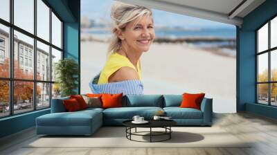 Trendy blond woman on a sandy beach Wall mural