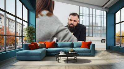 Two colleagues sitting working at an office table Wall mural