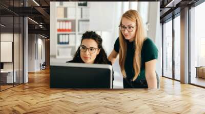 Two young women working at a desktop monitor Wall mural