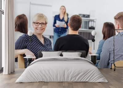 Woman smiling at camera during office meeting Wall mural