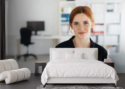 Young businesswoman with a quiet friendly smile Wall mural