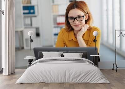 Young businesswoman working at a laptop Wall mural