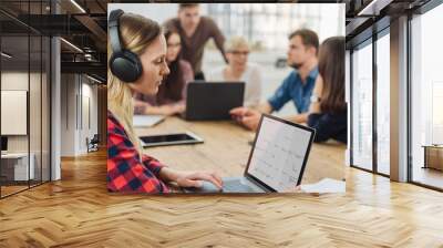 Young businesswoman working wearing headphones Wall mural