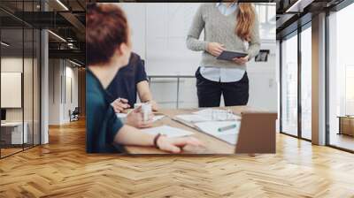 Young female team leader listening to a colleague Wall mural